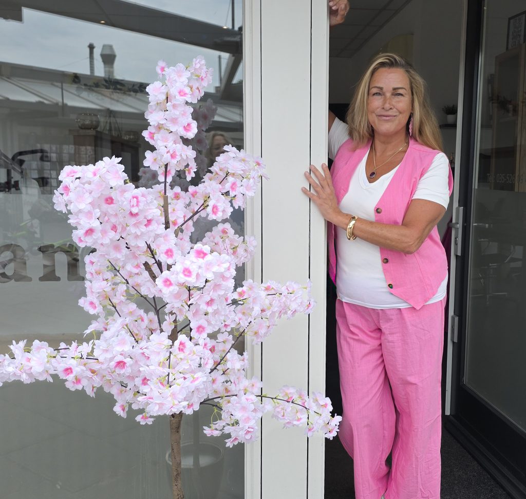 Bianca van Kapsalon Bianca in Huizen staat in de deuropening van de salon