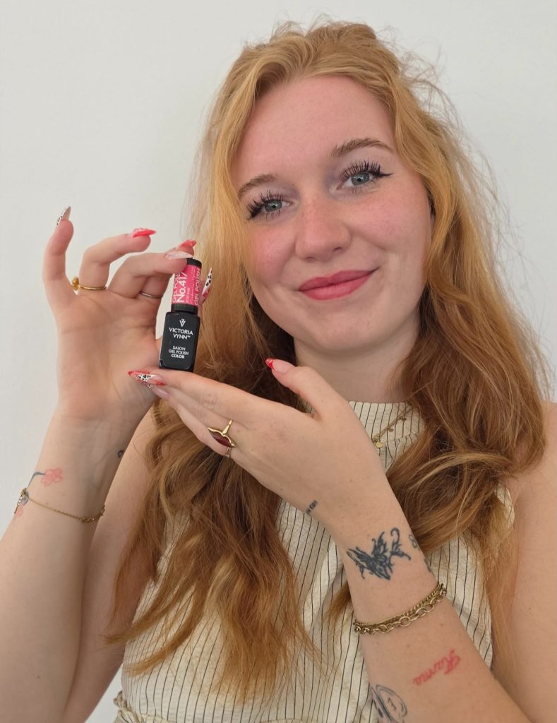 Fabienne van Nails by Fabienne houdt een flesje gelpolish vast met nail art op de nagels